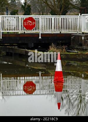 Cone on the ice, the freezing cold weather means water’s of the canal had frozen over and a traffic cone sits on the ice in front of a swing bridge. Stock Photo