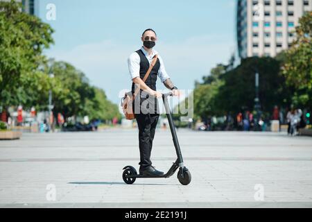 Businessman riding on electric scooter Stock Photo
