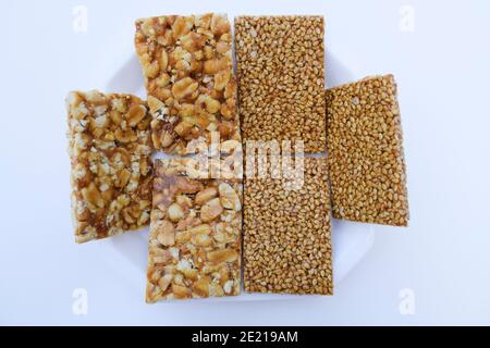 tilgul or sesame seeds sweet candy bar and Peanut groundnut chikki served prepared during festival of kites makar sankranti or uttarayan Stock Photo