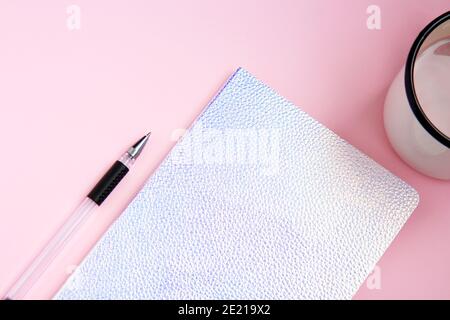 Open white notebook with blank white pages, pen and iron orange cup with cocoa on pink background. Flat lay Stock Photo