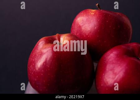 Red, juicy apples isolated on a black background. Dark food photography. Selective focus. Side view Stock Photo