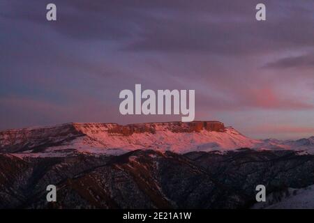 mountain plateau covered with snow illuminated by the setting sun Stock Photo