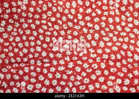 Red fabric texture with a pattern with white flowers background. Stock Photo