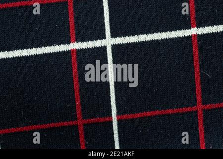 Black or dark blue fabric textile background texture with red and white pattern lines. Stock Photo