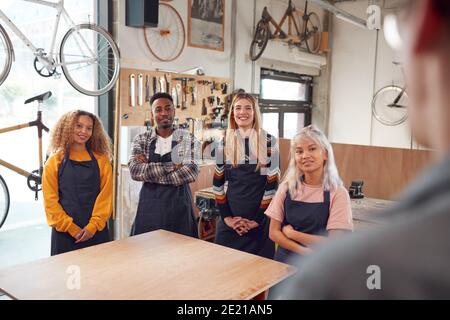 Multi-Cultural Team In Workshop Assembling Hand Built Sustainable Bamboo Bicycle Frame Stock Photo