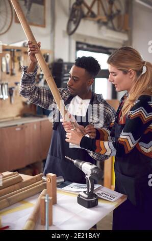 Multi-Cultural Team In Workshop Assembling Hand Built Sustainable Bamboo Bicycle Frame Stock Photo