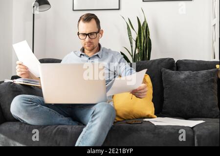 A freelancer with a laptop doing paperwork Stock Photo
