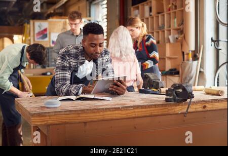 Male Craftsman In Carpentry Workshop For Bamboo Bicycles Using Digital Tablet Stock Photo