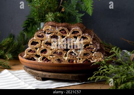 Monastic hut pie. Homemade cakes, sweet cake with cherry filling and cream. Collected from tubes, dough is rolled. Cake on the table. Festive food for Stock Photo