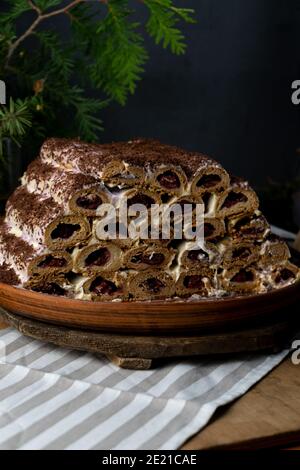 Monastic hut pie. Homemade cakes, sweet cake with cherry filling and cream. Collected from tubes, dough is rolled. Cake on the table. Festive food for Stock Photo