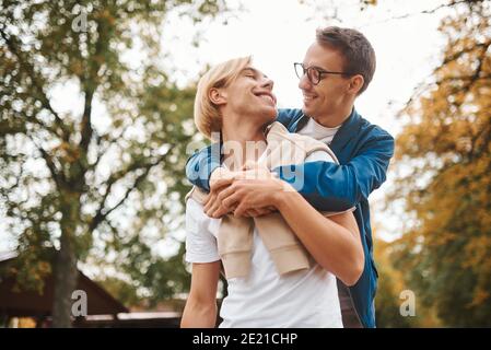 Loving gay couple walking outdoors. Two handsome men having romantic date in park. LGBT concept. Stock Photo