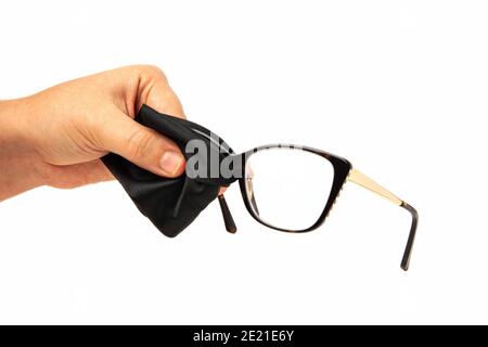 European woman hand cleaning rectangular eyeglass lens with black microfiber cloth isolated on white background Stock Photo