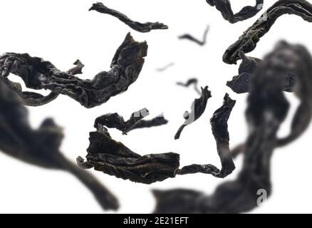 Dried black tea close up levitating on white background Stock Photo