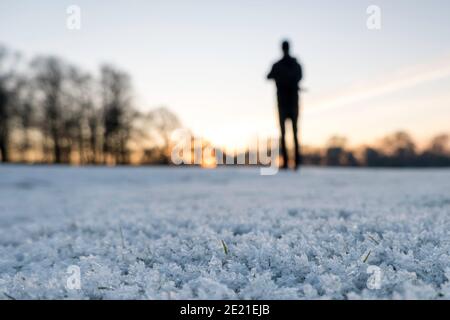 Silhouette of person on frosty field Stock Photo