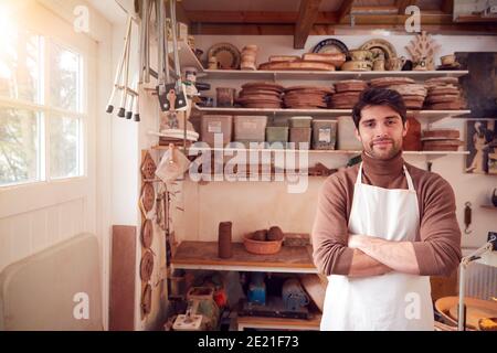 Portrait Of Male Potter Wearing Apron In Ceramics Studio Stock Photo