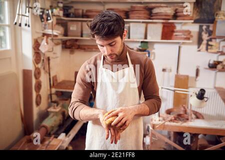 Male Potter Cleaning Hands With Sponge In Ceramics Studio Stock Photo