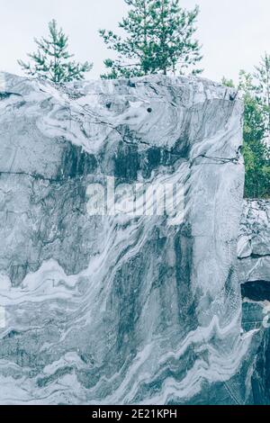 Karelia. Rock cut surface of white and grey marble in nature blue marble career. Stock Photo