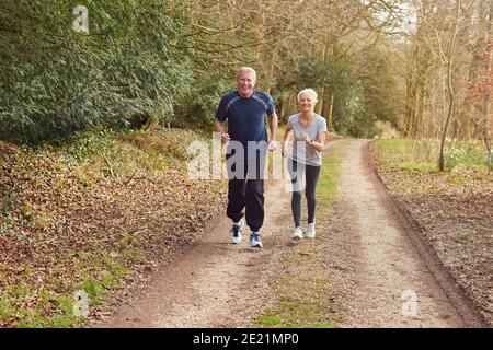 Senior Couple Exercising In Autumn Countryside During Covid 19 Lockdown Stock Photo