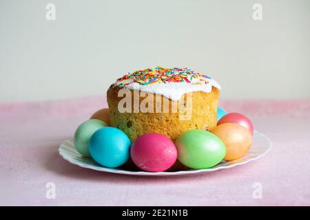 A plate with Easter eggs and cake. Simple minimalistic picture. Traditional Easter treats. Stock Photo