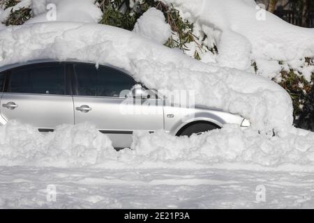 Madrid, Spain - January 10, 2021: Car parked, blocked and completely buried by snow and ice, on a snowy day, due to the Filomena polar cold front. Stock Photo