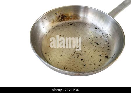 Skillet after used to fry food, isolated modern stainless steel skillet or pan with burning mark, used cooking oil in pan and burning small pieces of Stock Photo
