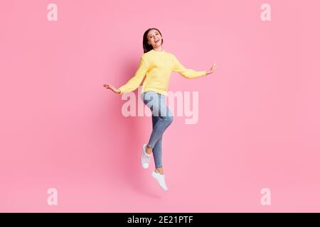 Full size photo of young beautiful happy smiling positive good mood girl jump fly isolated on pink color background Stock Photo