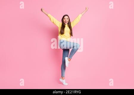Full size photo of young beautiful crazy ecstatic positive good mood girl raise fists leg isolated on pink color background Stock Photo