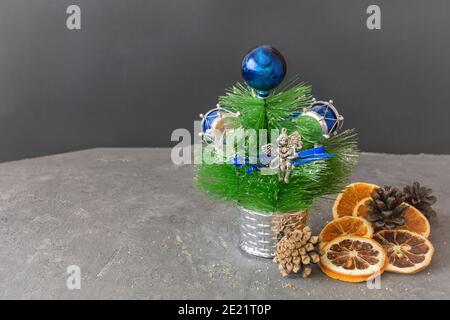Slices of dried oranges, lemons and pine cones on dark table with New Year's garland. Christmas composition, postcard. Selective focus, festive mood. Stock Photo