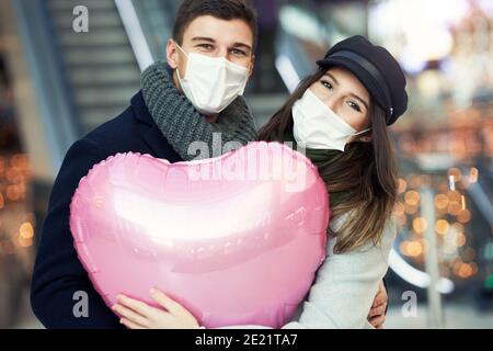 Happy couple celebrating Valentines Day in masks during covid-19 pandemic Stock Photo