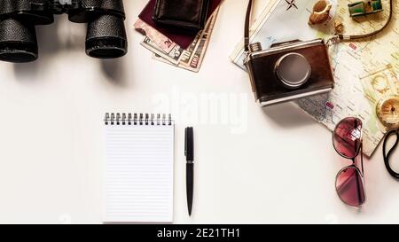 Top view of a pen and a notebook on the table with other traveling items Stock Photo