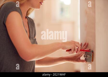 Close Up Of Female Electrician Fitting Light Switch At New Build Property Stock Photo