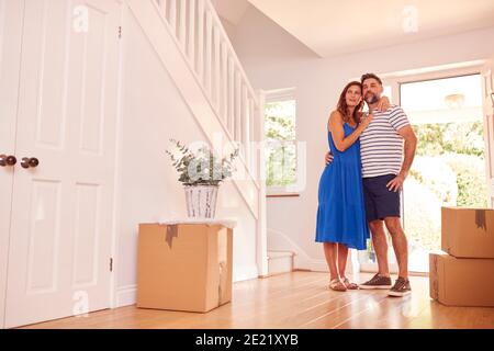 Mature Couple With Boxes Standing By Front Door Of New Home On Moving Day Stock Photo