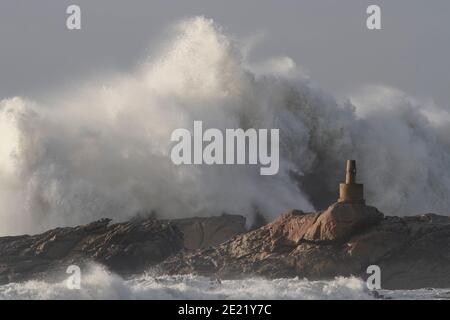 Big sea waves splash over cliffs seeing geodetic landmark. Northern portuguese rocky coast. Stock Photo