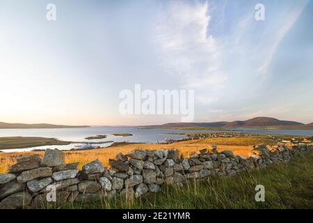 Aerial view of Stromness harbour on Orkney islands with drystone wall and grass in foreground