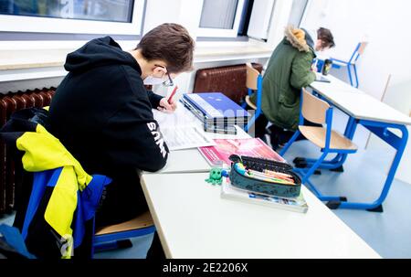 dpatop - 11 January 2021, Lower Saxony, Oldenburg: Students of a divided course of the upper school sit in a classroom of the Graf-Anton-Günther-Schule and work on an assignment. In Lower Saxony, the so-called scenario B with alternating lessons in divided classes applies in the first week only for final-year classes. Photo: Hauke-Christian Dittrich/dpa Stock Photo