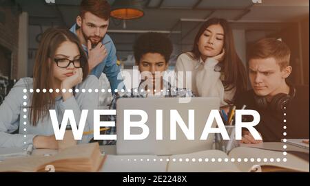 Smart serious students attending webinar together in front of laptop Stock Photo