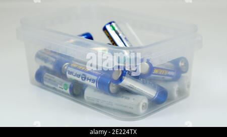Clear plastic box full of used household AA alkaline and lithium-ion batteries collected for recycling in special waste bins. Recycling and ecology pr Stock Photo