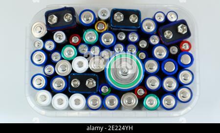 Clear plastic box full of used household AA alkaline and lithium-ion batteries collected for recycling in special waste bins. Recycling and ecology pr Stock Photo