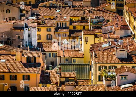 Lovely aerial close-up view of the residential buildings in the historic centre of Florence, Italy. The typical Tuscan ancient townhouses have... Stock Photo