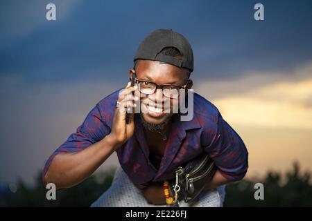 Selective focus shot of a handsome smiling African-American male talking on the phone Stock Photo