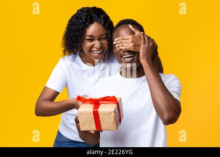 Cheerful african woman making Valentine surptise for her husband Stock Photo