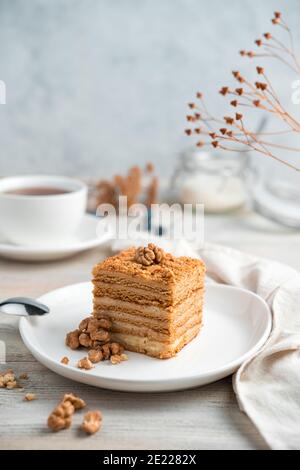 Honey cake with walnuts on a light background. Side view. Stock Photo