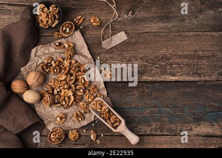 Peeled walnuts and shelled on a wooden background. Top view with space to copy. Stock Photo