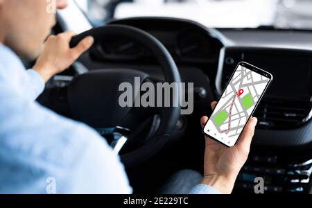 GPS Service App. Male Driver Using Navigation Application On Smartphone In Car Stock Photo
