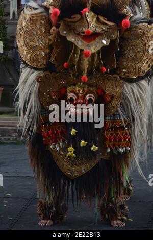 Balinese locals performing Barong, a mythical lion-like creature at a traditional ceremony in Bali. Stock Photo