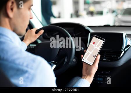 Man Using Smartphone Sitting In Car In Auto Center Stock Photo