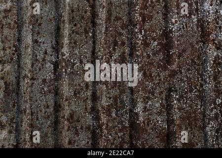 Rusty striped surface, with brown spots and silver spray on a steel grey background with vertical grooves. Stock Photo