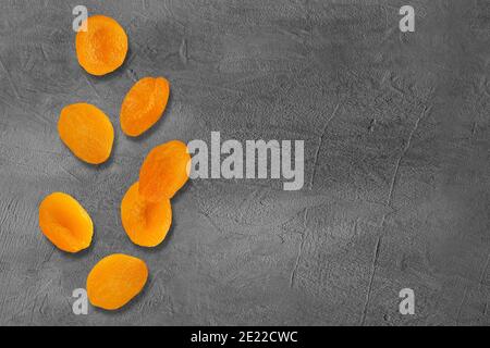 Flying slices dried apricot fruits on creative trendy background. Food levitation concept. Flat lay with copy space. Stock Photo