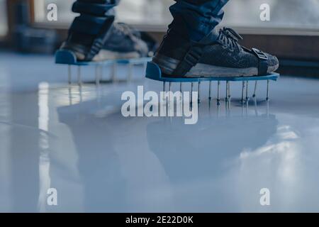 Worker with special nail slippers used in epoxy flooring works Stock Photo