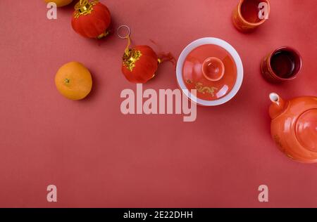 Top view accessories Chinese new year festival decorations of tangerines leaf red decoration in tea Stock Photo